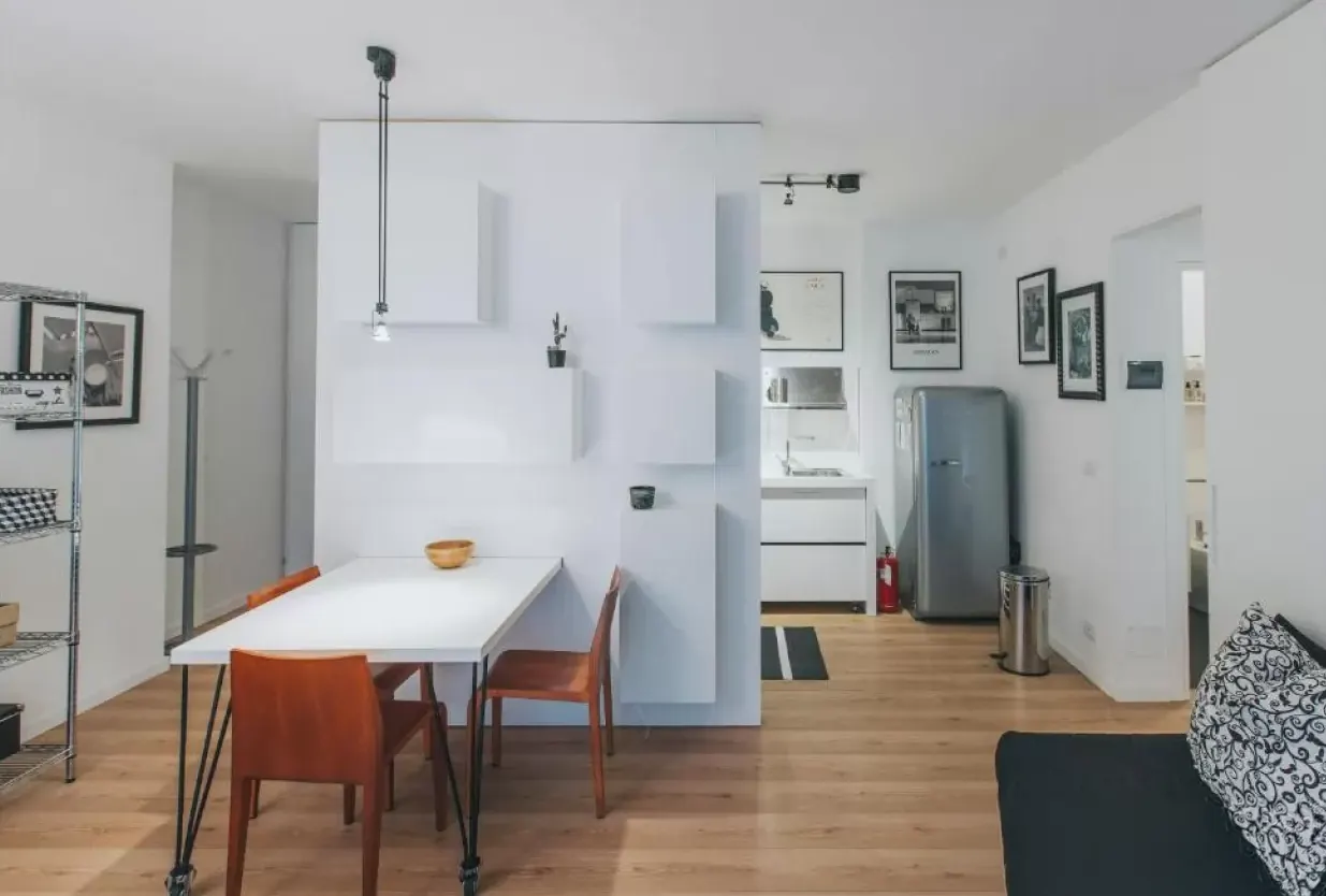 Interno di un monolocale moderno con tavolo da pranzo, cucina e divano