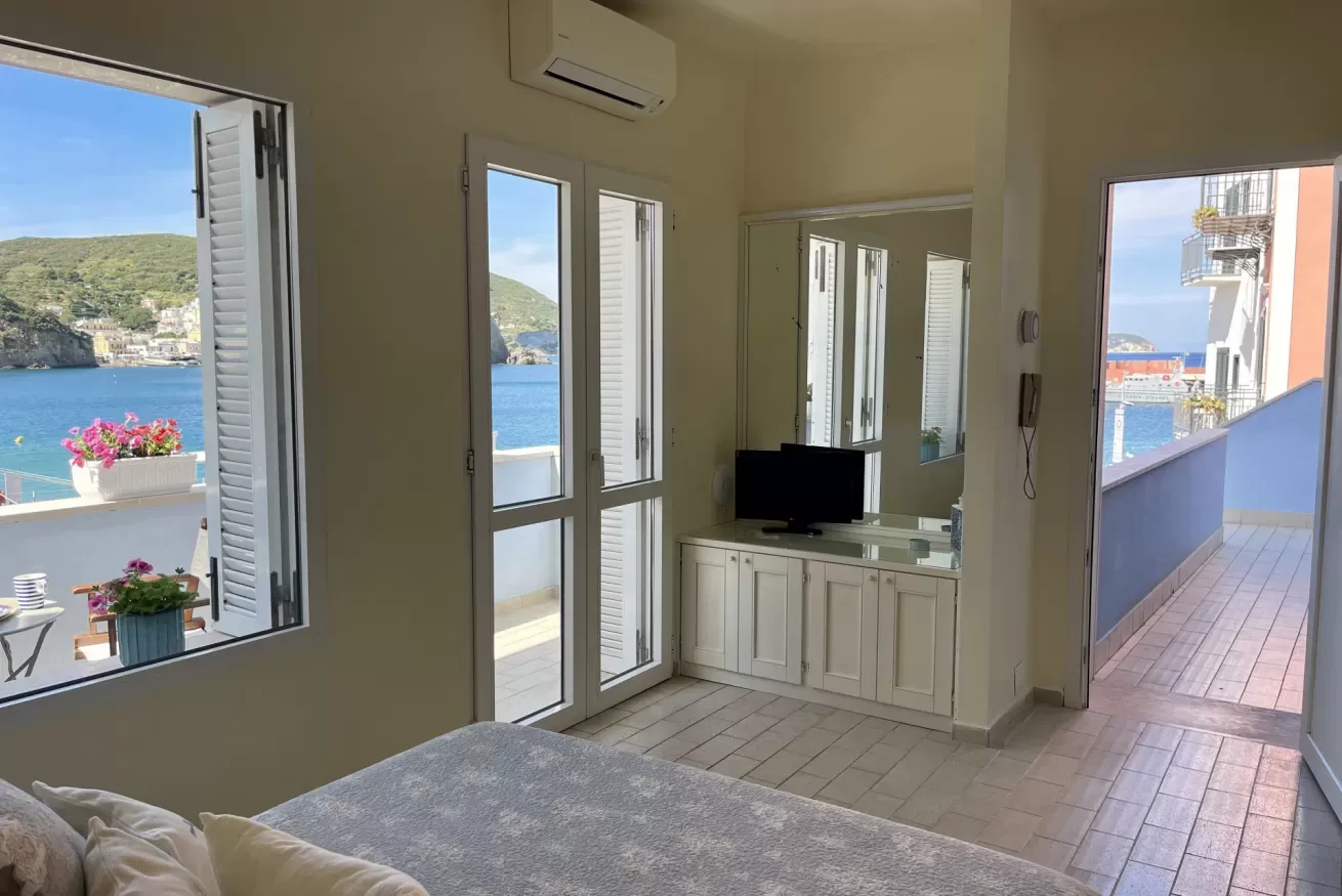 Camera con vista sul mare e balconi aperti su una baia