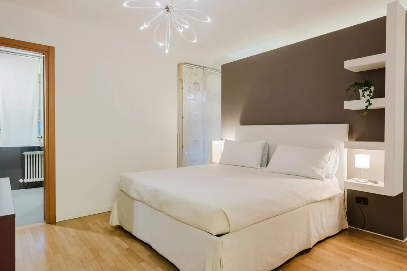 Camera da letto moderna con letto matrimoniale, parete marrone e lampade integrate