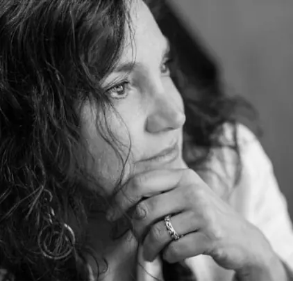 Donna in bianco e nero con la mano sul mento, in posa pensierosa e rivolta di lato